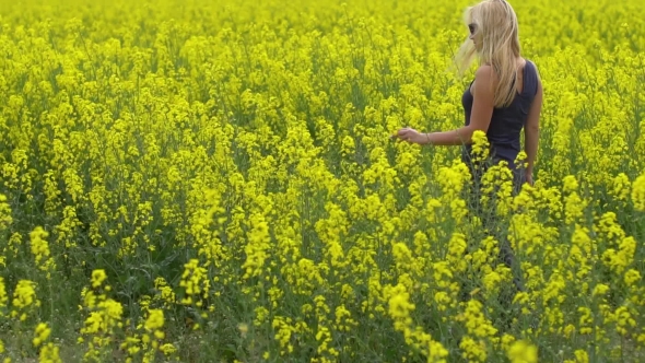 Young Blonde Woman Posing in Beautiful Rapeseed Field