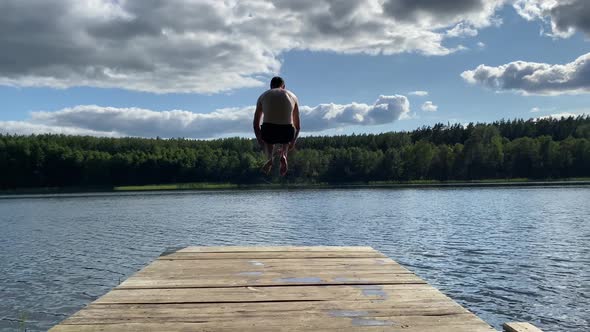 Handsome young man jumping into the water and making a splash