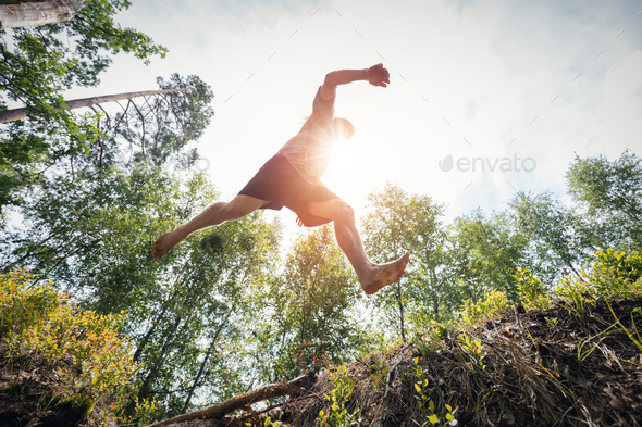 Young man jumping in the forest.