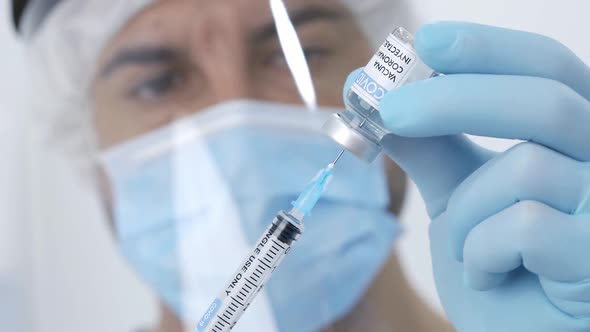 Crop doctor filling syringe with drug in hospital alt