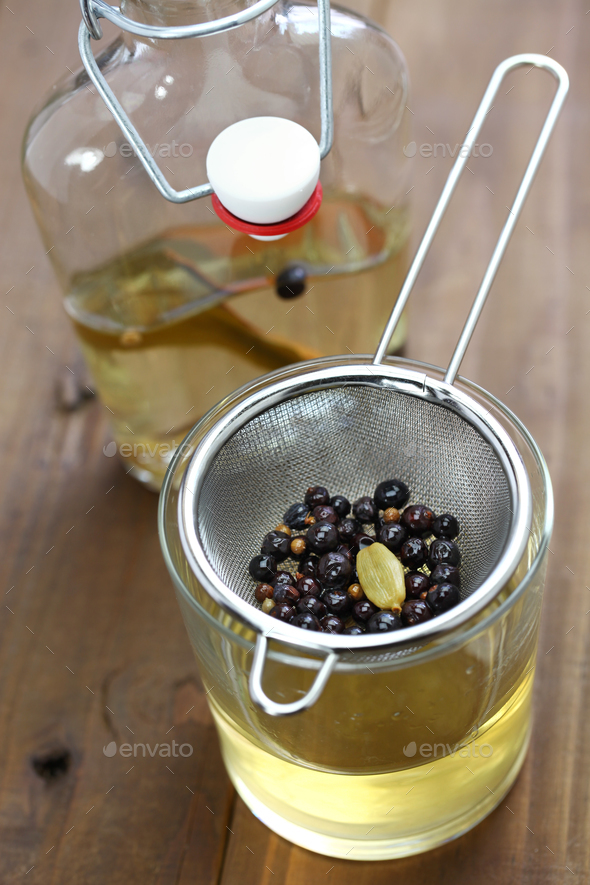 making homemade gin, straining infused liqueur Stock Photo by motghnit