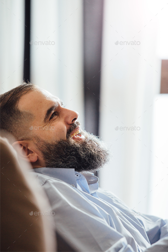 Side view of laughing bearded man