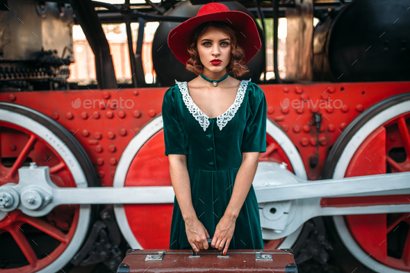 Woman with suitcase against steam locomotive - Stock Photo - Images