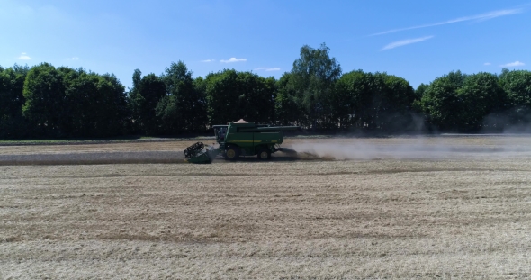 Aerial Side Shot of Harvesting of Wheat By Green Harvester
