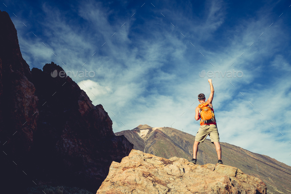 Man celebrating success in mountains, arms outstretched - Stock Photo - Images