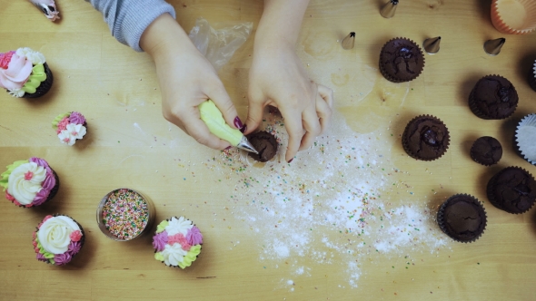 Top View of Female Hands Decorating the Chocolate Cupcakes alt