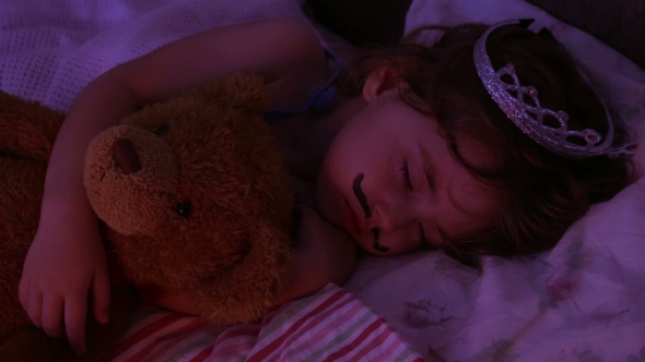 Portrait Little Girl Sleeping in Bed. Girl with a Crown of Princess on Her Head in Bed Hugging