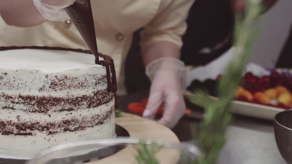 Female Pastry Chef Decorates Sponge Cake with Melted Chokolate