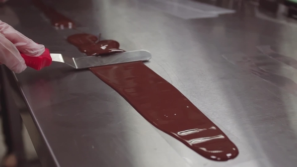  Pastry Chef Hands in Gloves Smears Melted Chocolate Using Icing Spatula