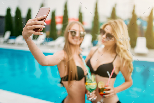 Two sexy girls makes selfie near the swimmimg pool - Stock Photo - Images