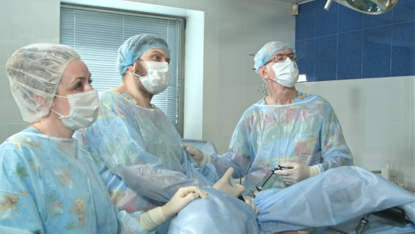 Team of Doctors Working Together During a Surgery in an Operating Room ...