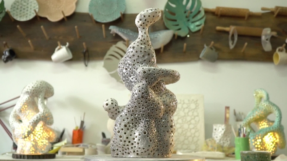 Clay Sculpture Rotates on a Potter's Wheel in the Workshop alt