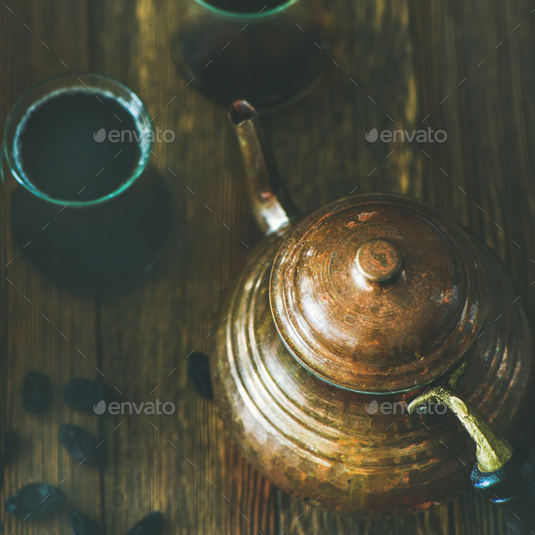 Oriental teapot, black tea in glasses and raisins, square crop - Stock Photo - Images