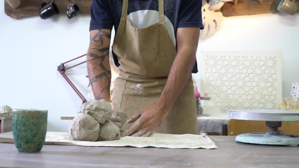 Potter Kneads a Clay in the Light Potter Working Space alt