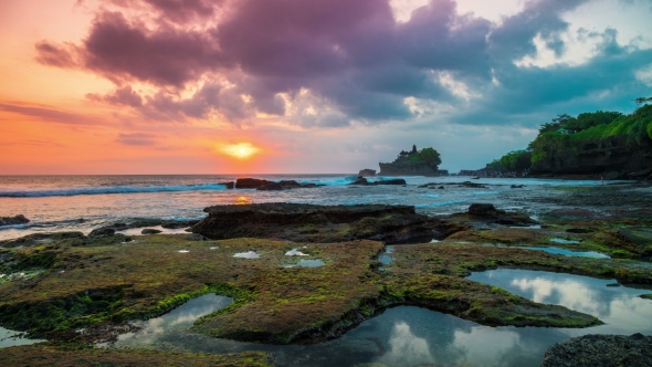 Sunset  at the Broken Beach. In the Distance One Can See the Temple of Tanah Lot on the Island o alt