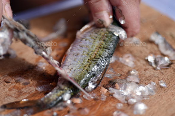 Firsherman gutting and cleaning scales of freshly caught fish