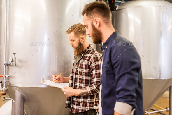men with clipboard at craft brewery or beer plant - Stock Photo - Images