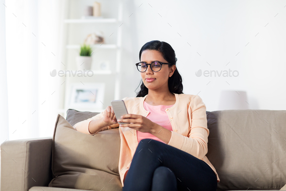 happy woman texting message on smartphone at home - Stock Photo - Images
