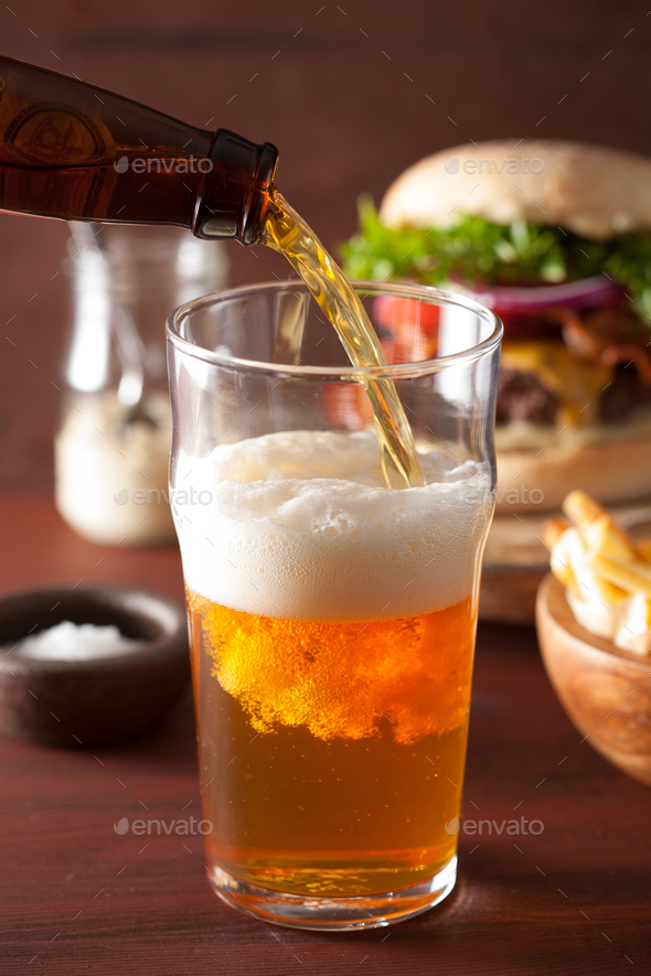 pouring india pale ale beer into pint glass and fast food