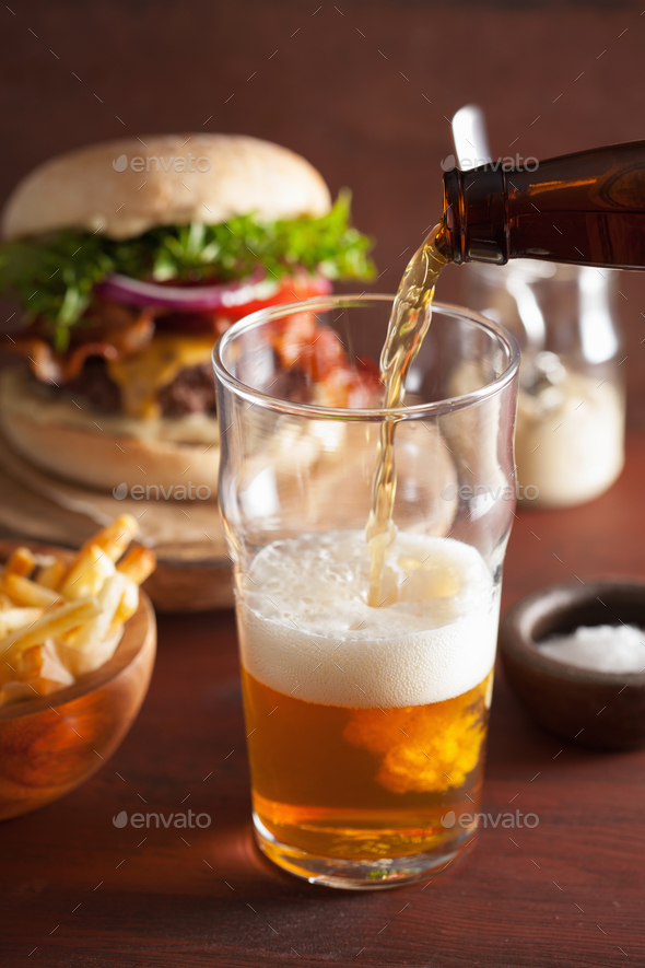 pouring india pale ale beer into pint glass and fast food