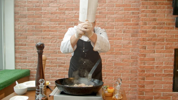 Chef Adding Lemon Juice in Pan with Fried Seafood alt