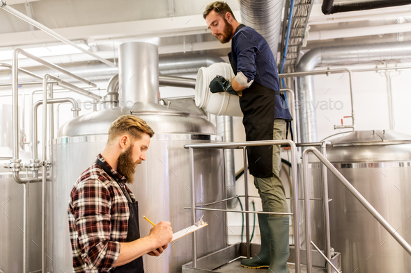 men working at craft brewery or beer plant - Stock Photo - Images
