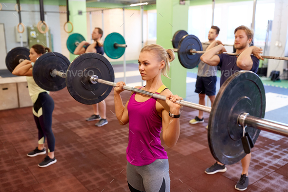group of people training with barbells in gym