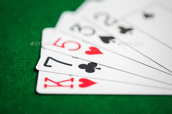 poker hand of playing cards on green casino cloth - Stock Photo - Images