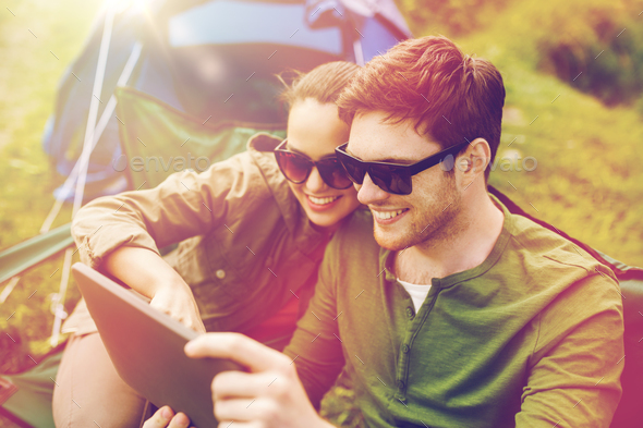 happy couple with tablet pc at camping tent - Stock Photo - Images