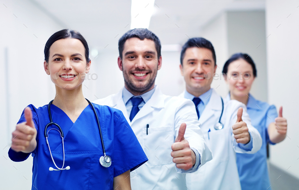 medics or doctors at hospital showing thumbs up