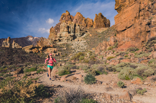 Woman running in mountains, trail runner