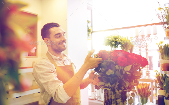 smiling florist man with roses at flower shop