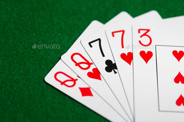 poker hand of playing cards on green casino cloth