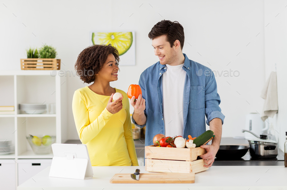 happy couple with healthy food at home kitchen