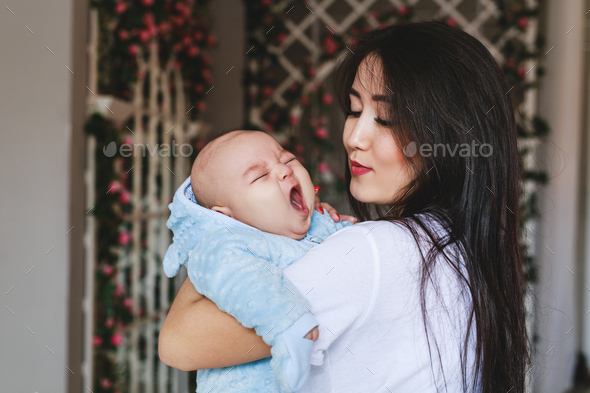 Portrait of a cute asian baby boy yawning - Stock Photo - Images