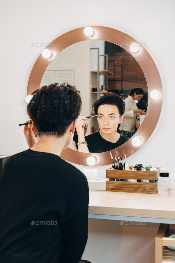 Attractive woman at the mirror in beauty studio - Stock Photo - Images