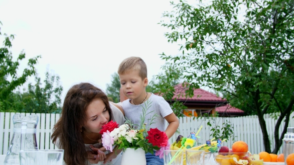 Summer, in the Garden Mom with a Four-year-old Son Make a Bouquet of Flowers The Boy Likes It Very alt