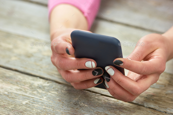 Female manicured hands with phone