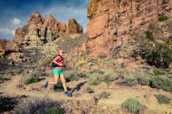 Young woman running in inspirational mountains landscape - Stock Photo - Images