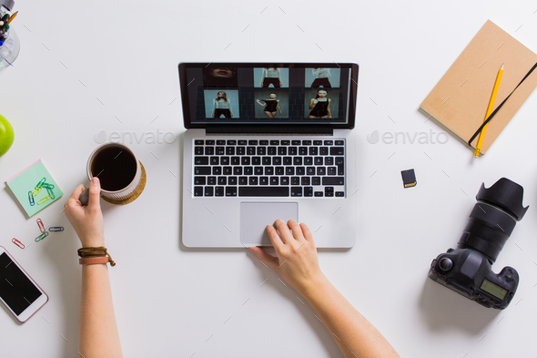 woman hands with camera working on laptop at table - Stock Photo - Images