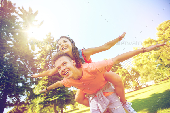 happy teenage couple having fun at summer park - Stock Photo - Images