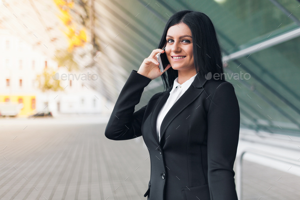 Successful business woman with mobile phone in an urban setting