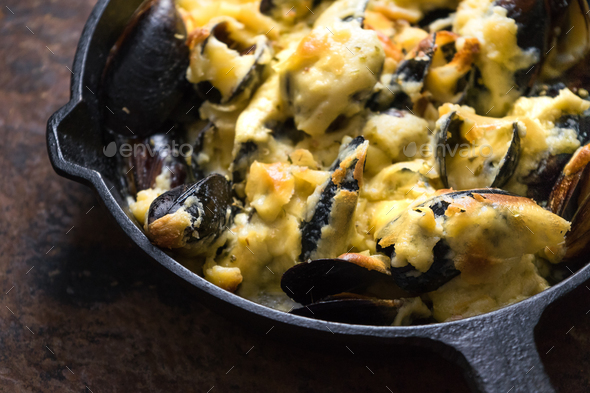 Frying pan with mussels under cheese sauce on a brown background close-up Stock Photo by Deniskarpenkov