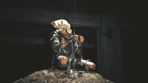 a Prisoner in Chains Is Closed in the Basement Where a Little Light Penetrates alt