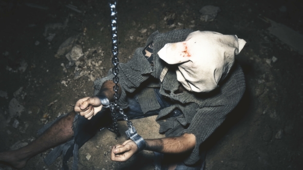 a Prisoner in Chains Is Closed in the Basement Where a Little Light Penetrates alt