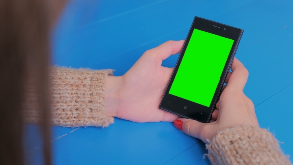 Woman Looking at Smartphone with Green Screen