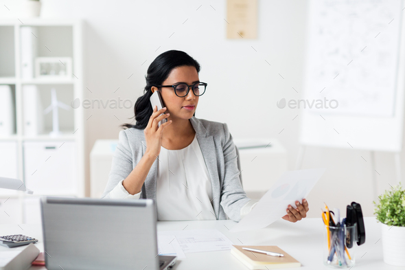 businesswoman calling on smartphone at office Stock Photo by dolgachov