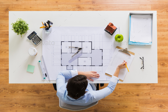 architect with blueprint writing to clipboard - Stock Photo - Images