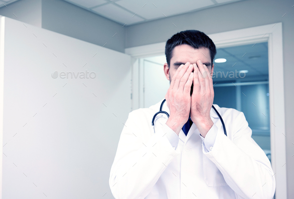 sad or crying male doctor at hospital ward