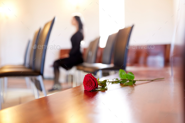 red roses and woman crying at funeral in church